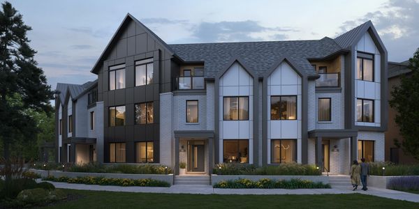 Modern townhouse complex with sleek design and large windows at dusk.