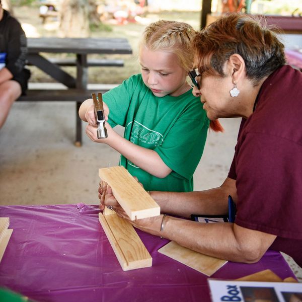 A woman helping a girl with a project