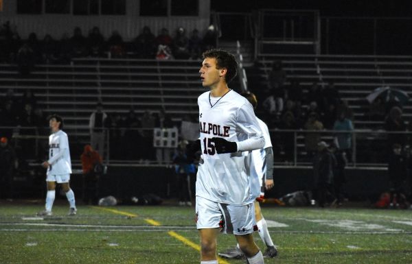Soccer player in white jersey on the field at night.