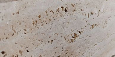 Close-up of a beige porous stone surface with natural holes and texture.