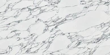 Large white marble slab with intricate gray veining on a wooden stand.