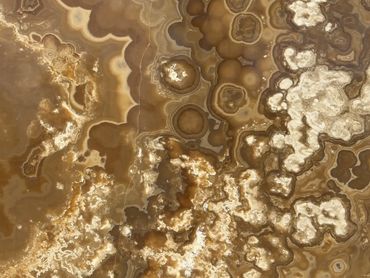 Close-up of a brown and white agate stone surface with intricate patterns.