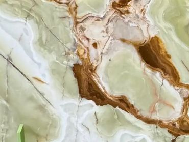 Close-up of a polished marble surface with green, white, and brown veins.