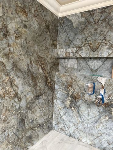 Luxurious marble wall and floor with intricate veining and a recessed shelf.