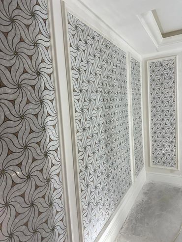 Decorative wall panels with intricate swirling patterns framed in white molding.
