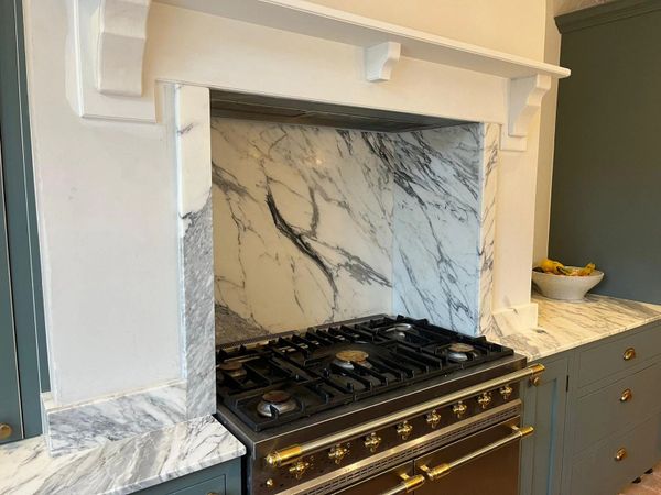 Elegant kitchen stove with marble backsplash and countertops.