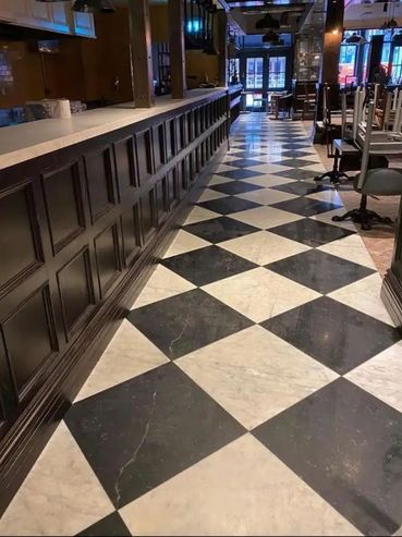Empty restaurant interior with black and white checkered floor tiles.