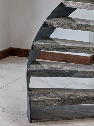 Close-up of a modern staircase with stone steps and sleek design.