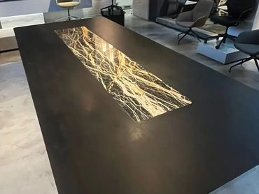 Modern black table with a striking marble inlay centerpiece.