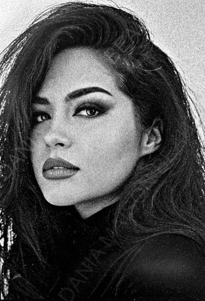 Black and white close-up portrait of a woman with intense eyes and flowing hair.