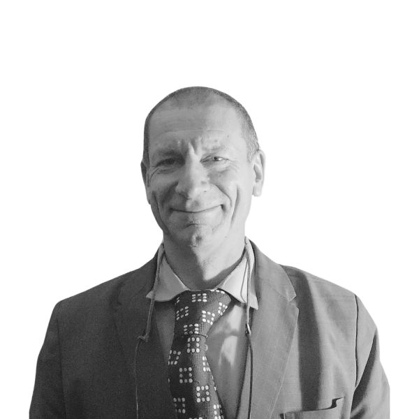 Smiling man in a suit and patterned tie against a white background.