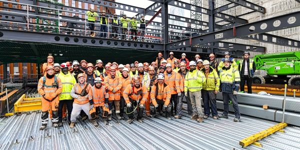 A diverse group of construction workers posing at a building site.