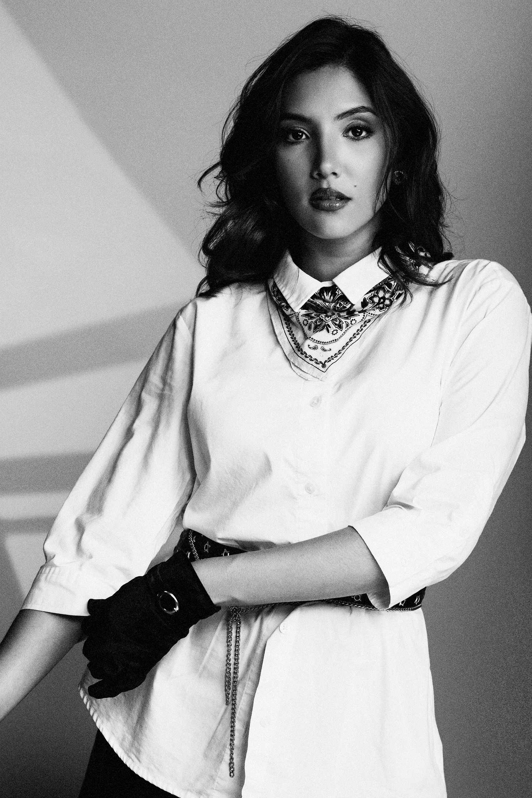 Black and white portrait of a woman with a scarf and gloves.