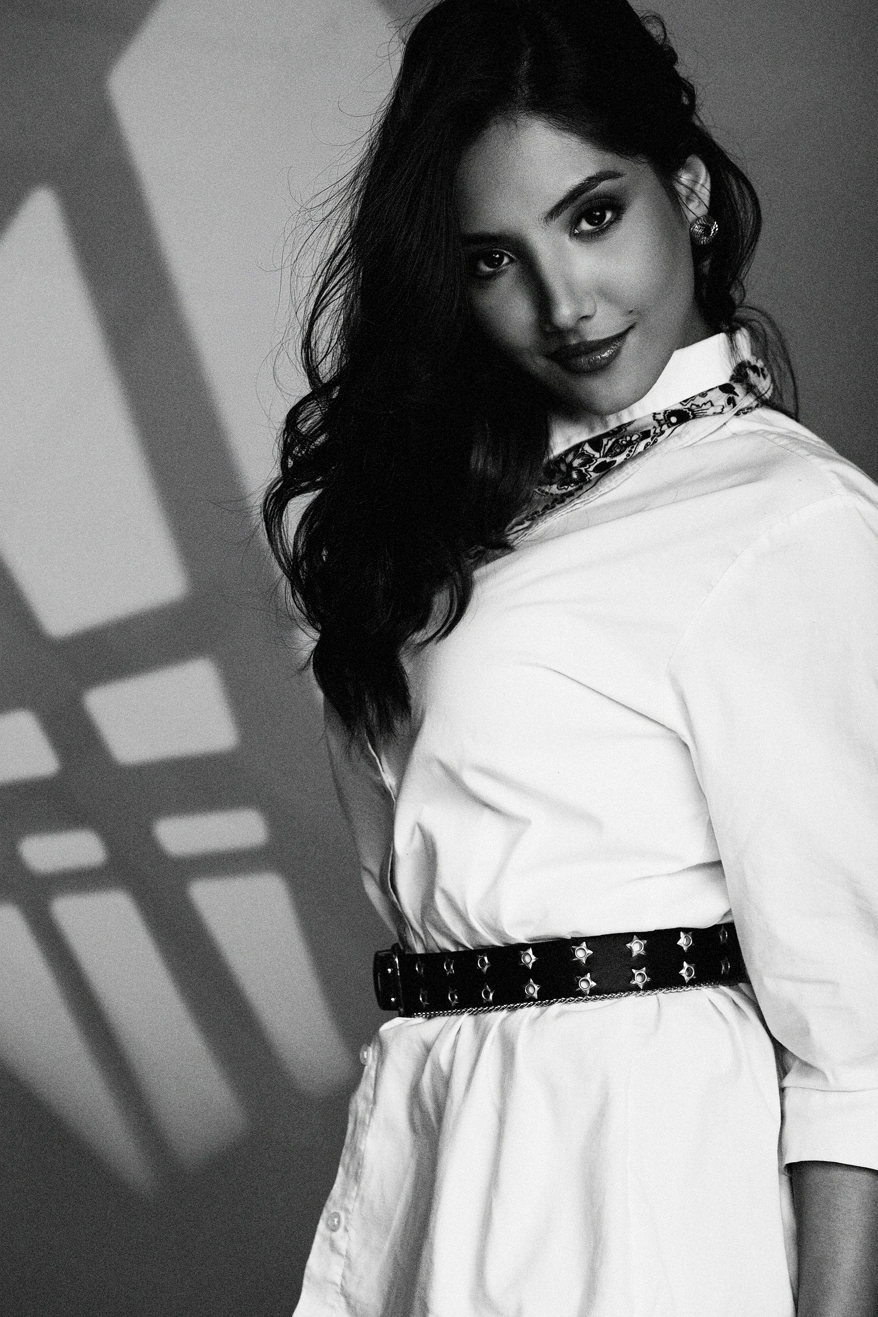 Black and white portrait of a woman with dark hair and a confident smile.