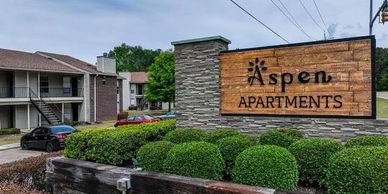 Aspen Apartments entrance sign with landscaping.