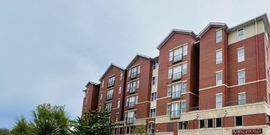 A multi-story red brick building under a clear sky.