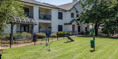 Apartment building with small playground and green lawn.