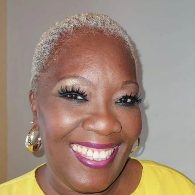 Smiling woman with short blonde hair and vibrant makeup.