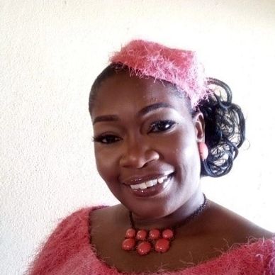 A smiling woman wearing a pink fuzzy outfit and matching accessories.