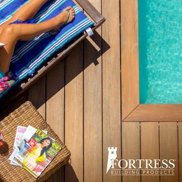 Relaxing poolside scene with a woman on a lounge chair and magazines nearby.