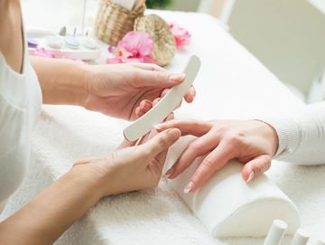 A person filing another's nails during a manicure.