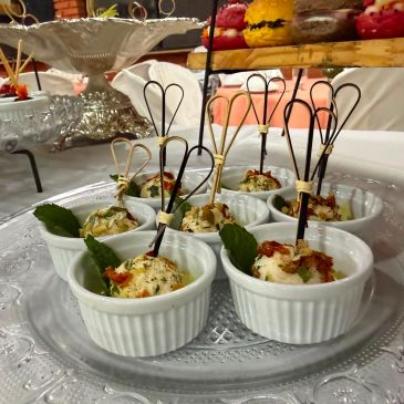 Porções individuais de aperitivos em ramequins brancos com palitos decorativos.