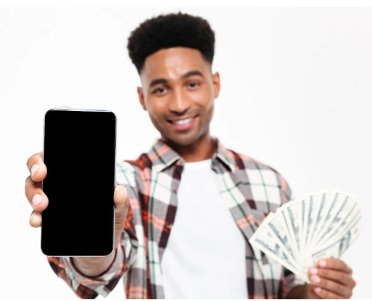 Man smiling, showing smartphone and fanned cash in hand.