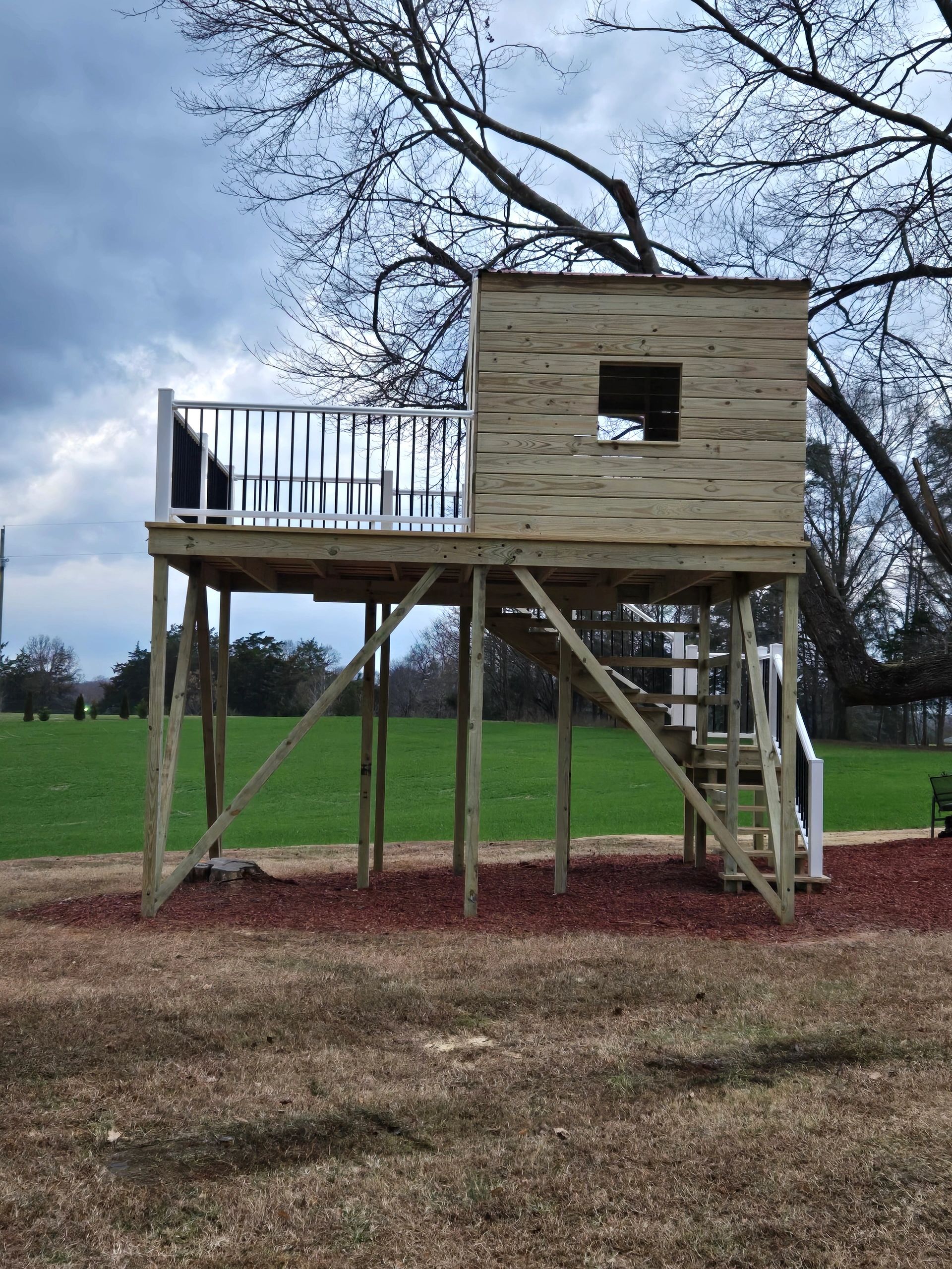 Elevated kids' playhouse with  platform deck and stairs