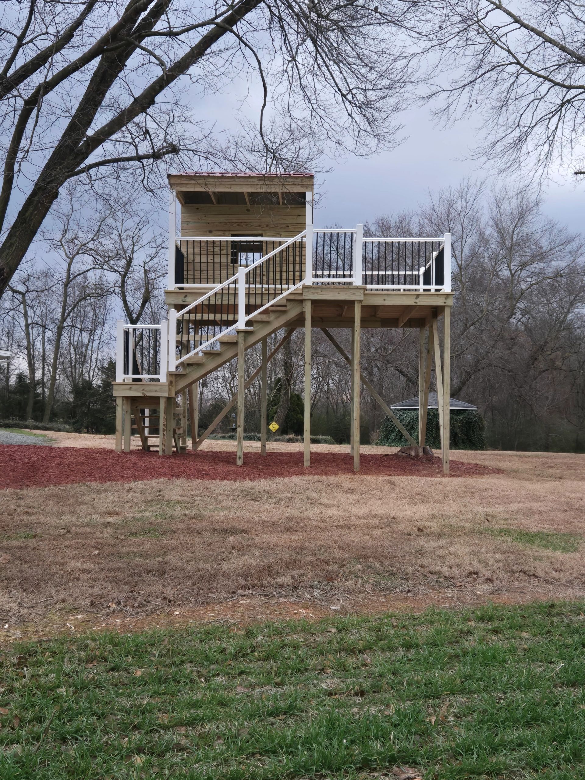 Elevated kids' playhouse with  platform deck and stairs