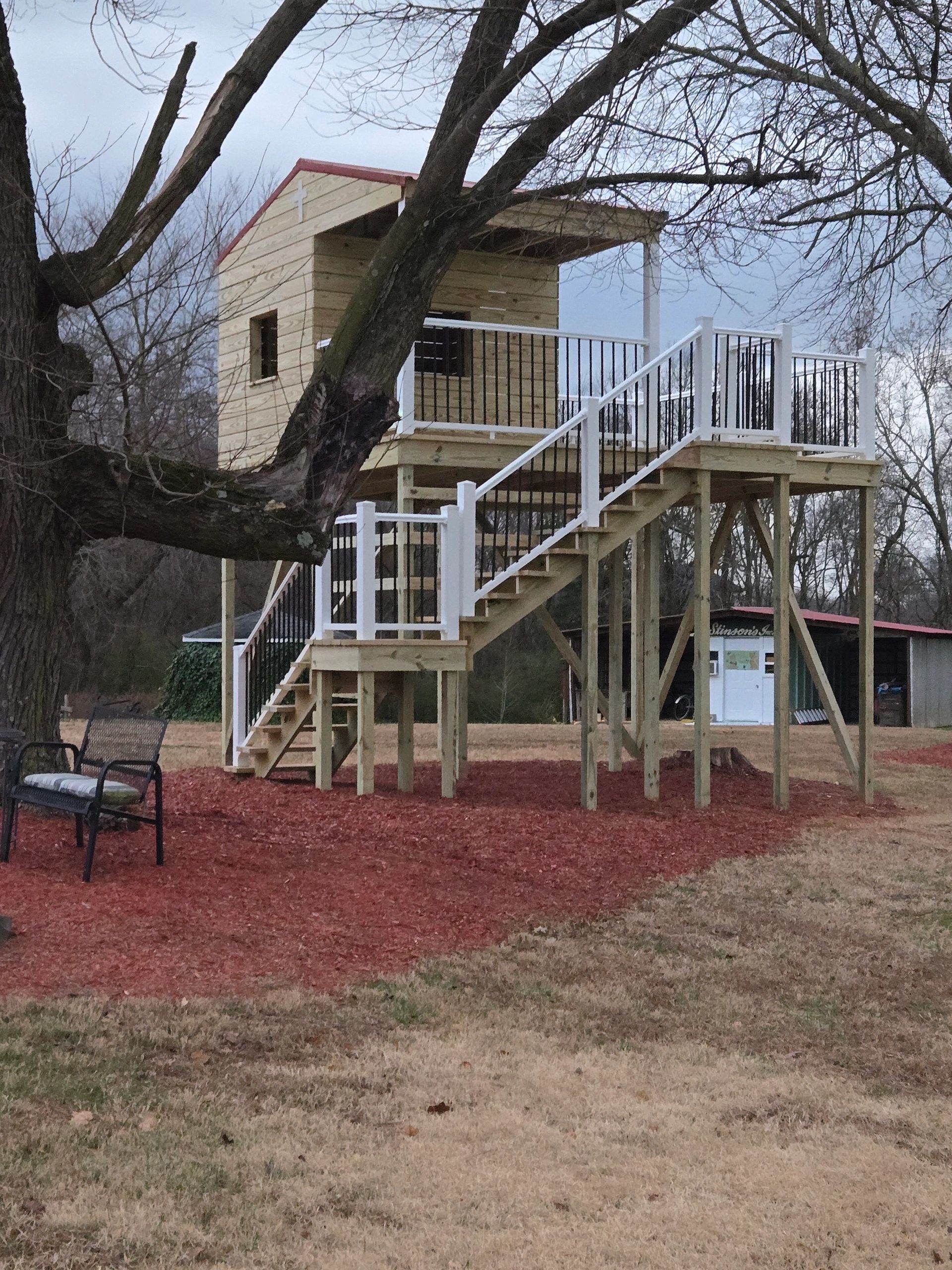 Elevated kids' playhouse with  platform deck and stairs