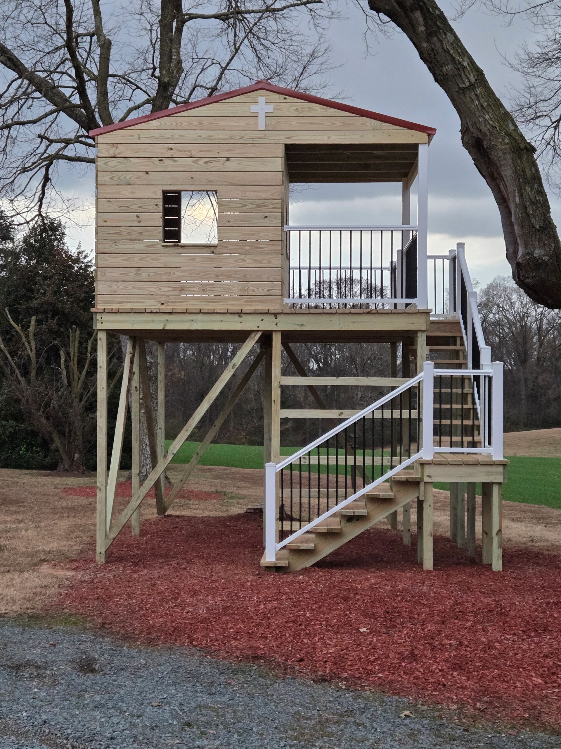 Elevated kids' playhouse with  platform deck and stairs