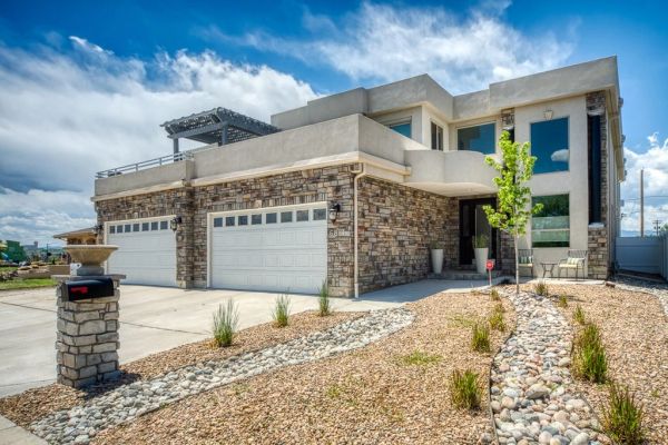 Modern house with stone and stucco exterior and dry landscaping.