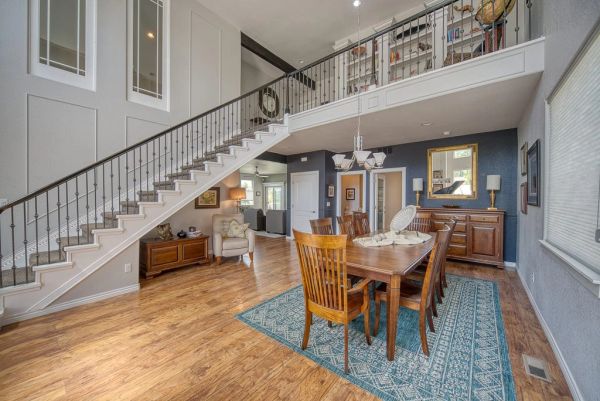 Spacious dining area with wooden furniture and staircase.