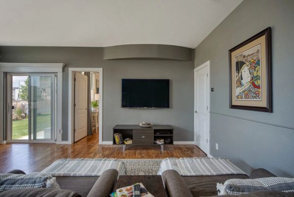 Modern living room with wall-mounted TV and sliding glass door.