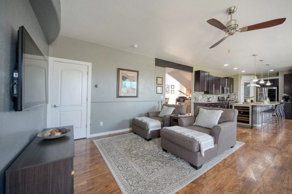 Cozy modern living room with armchairs and a ceiling fan.