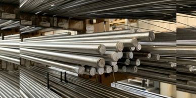 Stacks of cylindrical metal rods stored in a warehouse or factory.