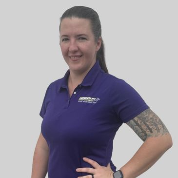 Woman in a purple polo shirt with a tattoo on her arm.