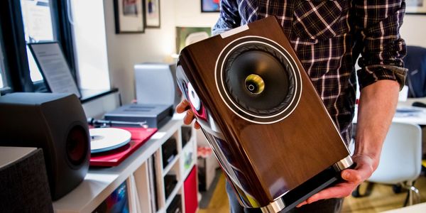 Staff member showing a premium speaker in the shop display area