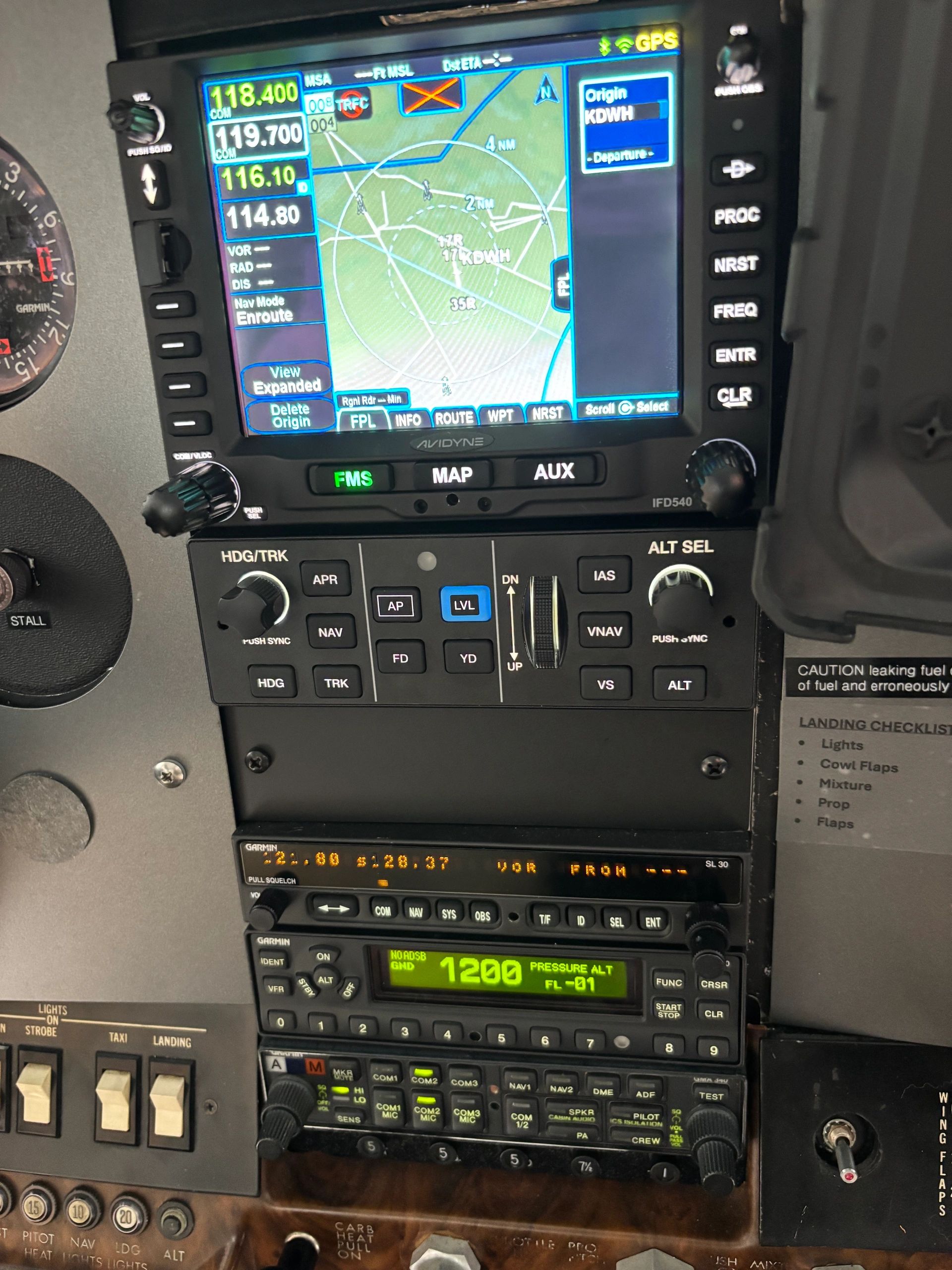 Cockpit control panel with GPS navigation and communication radios active.