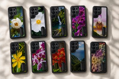 Ten phone cases with vibrant floral and nature designs arranged on a surface.