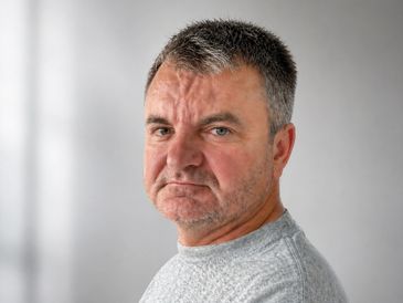 Portrait of a middle-aged man with a serious expression.