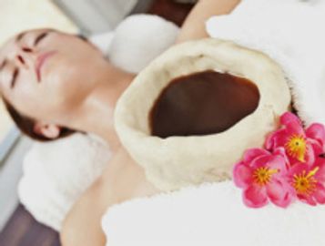 Relaxing spa scene with woman and coconut bowl.