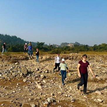 A group of people walking on rocky terrain under clear blue sky.