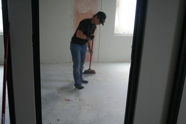 crew technician sweeping offices at an unfinished construction site in eau claire 