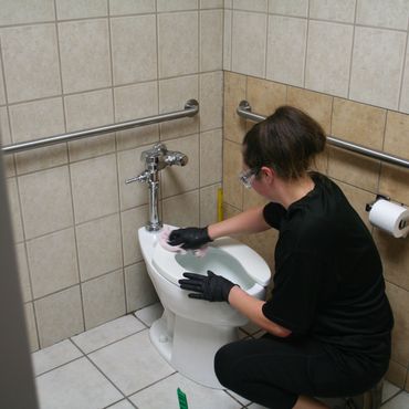 j & f facility services technician cleaning toilet seat at a warehouse in eau claire wi