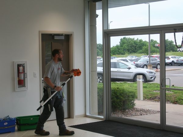 J & F Facility Services employee washing windows at a car dealership in Eau Claire, Wisconsin