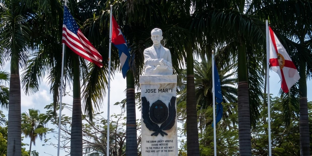 Statue of Jose Marti surrounded by palm trees and flags.