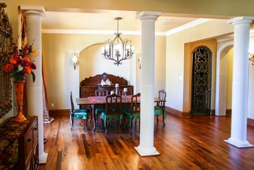 A dining area with white pillars and classic wooden furniture