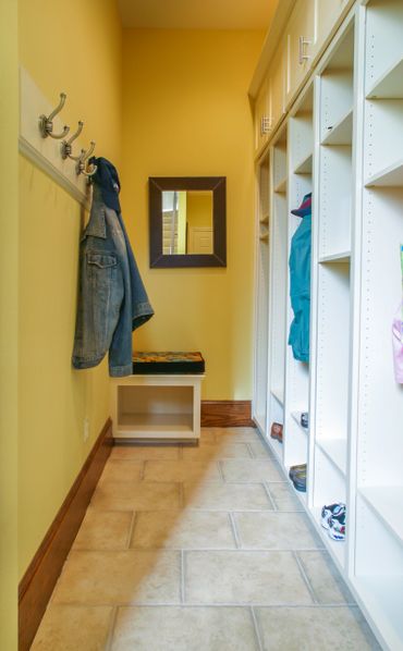 A narrow room with open cabinets and a wall hanger