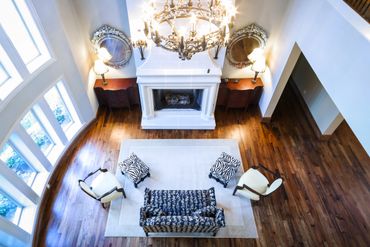 A dark blue sofa and white chairs in front of a white fireplace